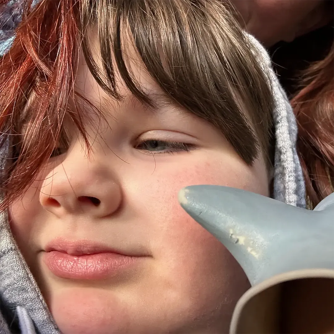 Elliot with his shark puppet hugging his mom