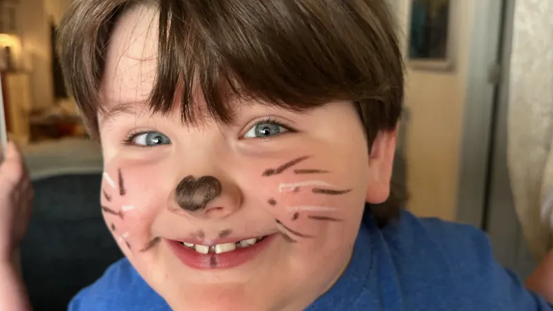 small boy with autism with face paint and a big smile